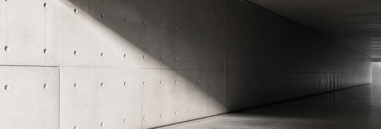 Polished concrete corridor wall with a long shadow gradient
