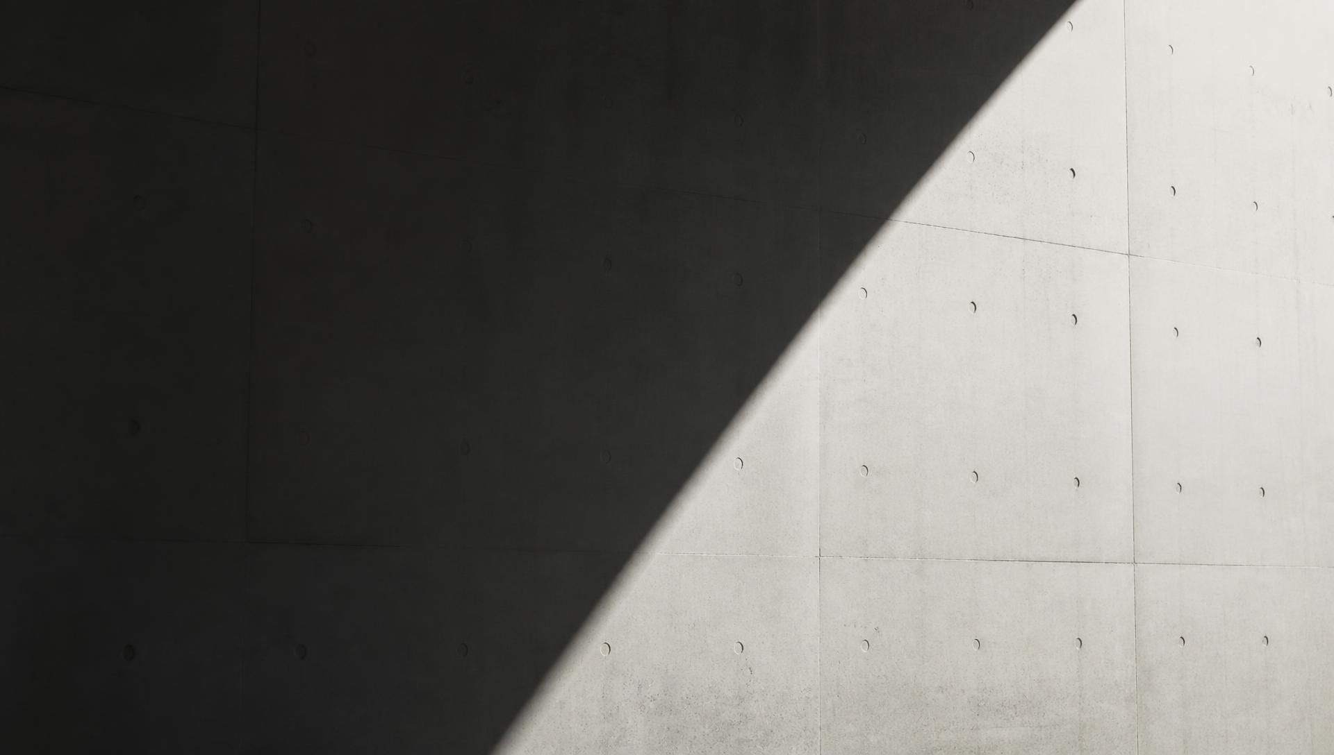 Polished concrete wall with a hard diagonal shadow falling across it