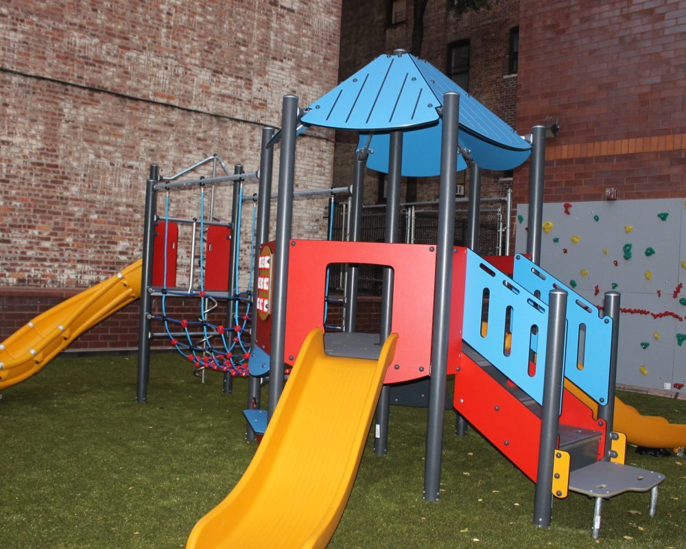 Playground structure beside a brick building